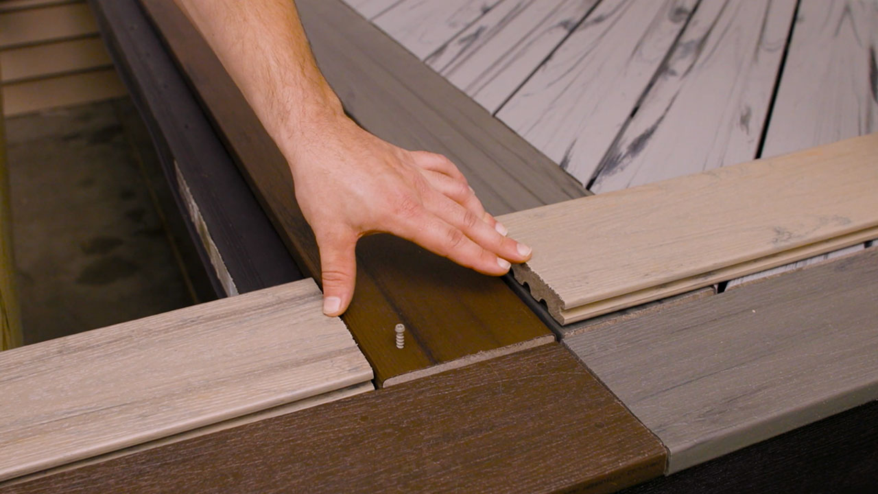 Breaker board installed perpendicular to composite decking to improve deck stability and complement picture framing transition boards