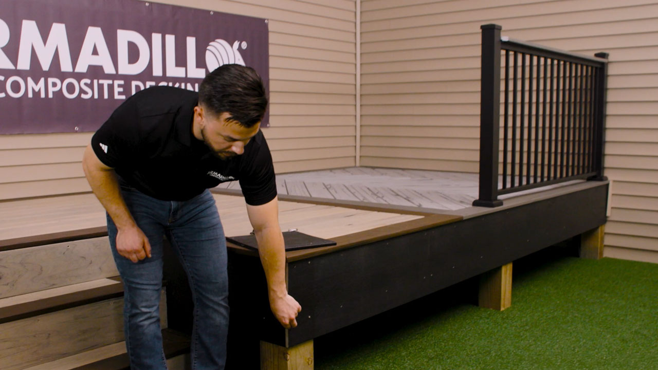 Derek pointing at composite deck fascia installed on side of deck