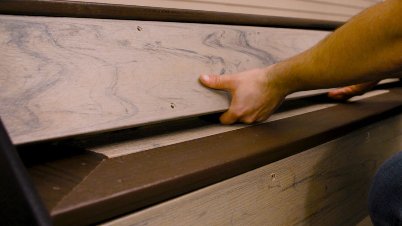 Derek assembling composite deck treads and risers on steps to create picture frame deck pattern