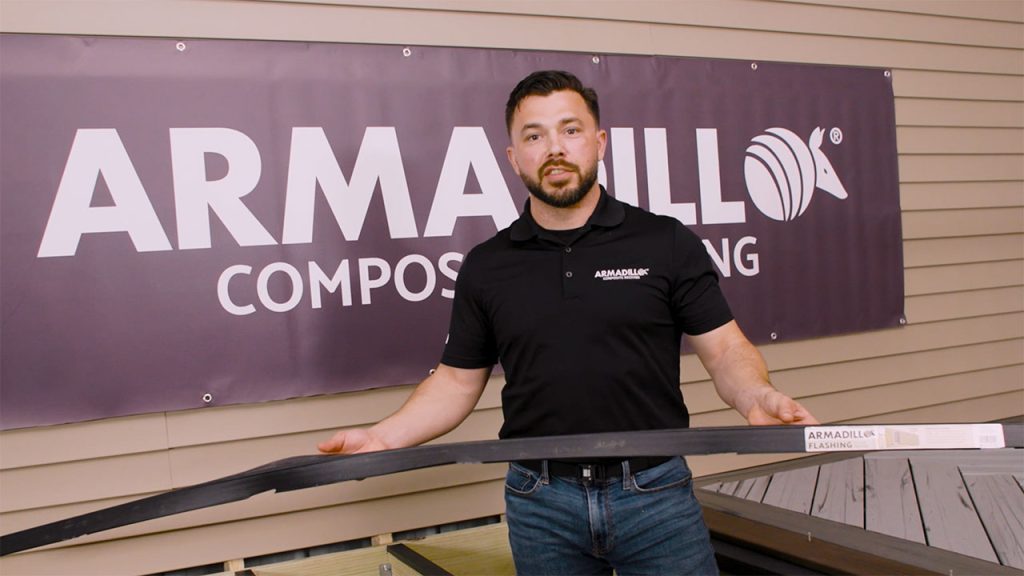 Derek holding a piece of Armadillo deck flashing for protecting the ledger board and joists