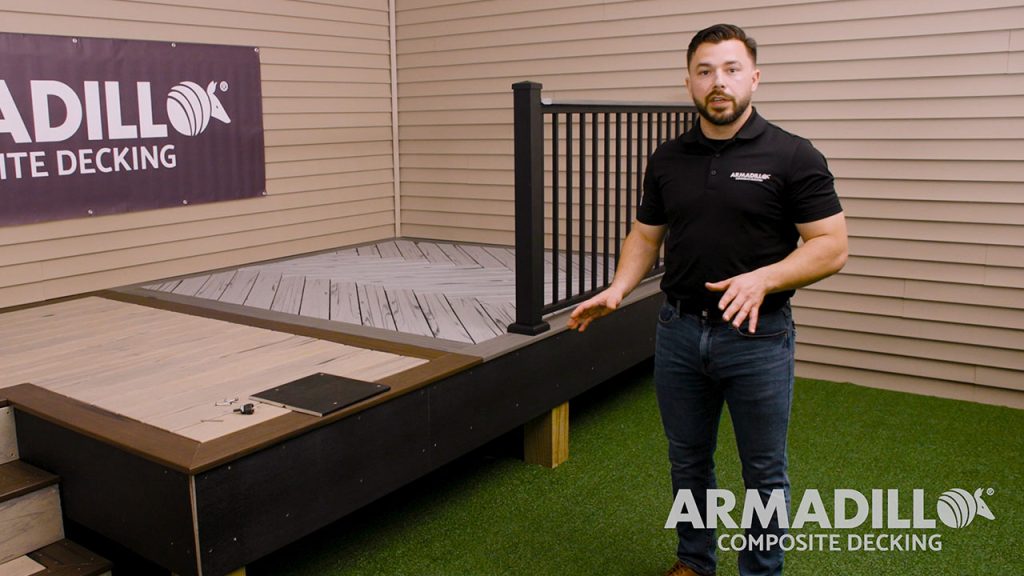 Derek standing in front of composite deck featuring Armadillo fascia installation