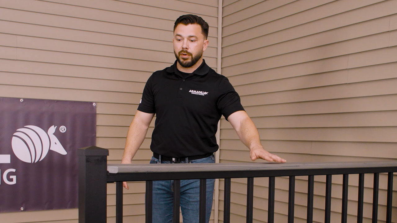 Derek standing next to railing with composite decking products on a deck showing a professional finish