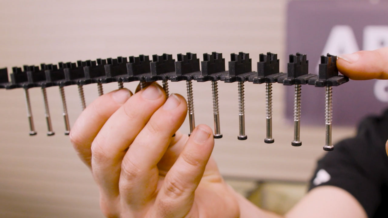 Close-up of TurboClip hidden fastener directional design showing angled crush block securing composite deck board